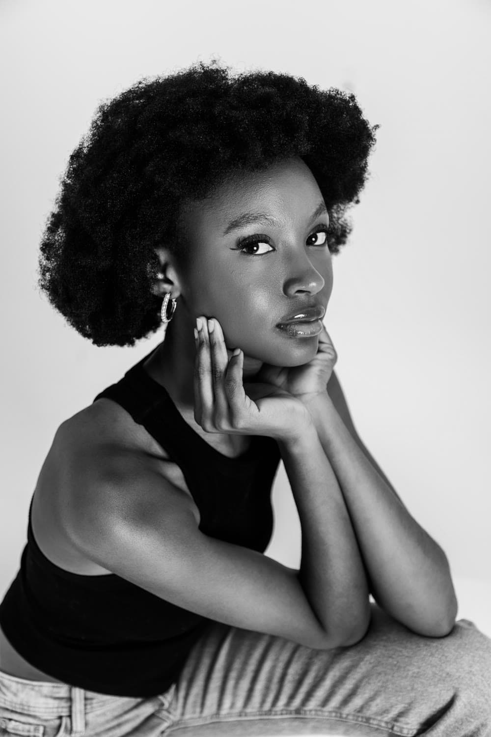 Studio portrait, hand resting at the chin, high-key ground, black and white